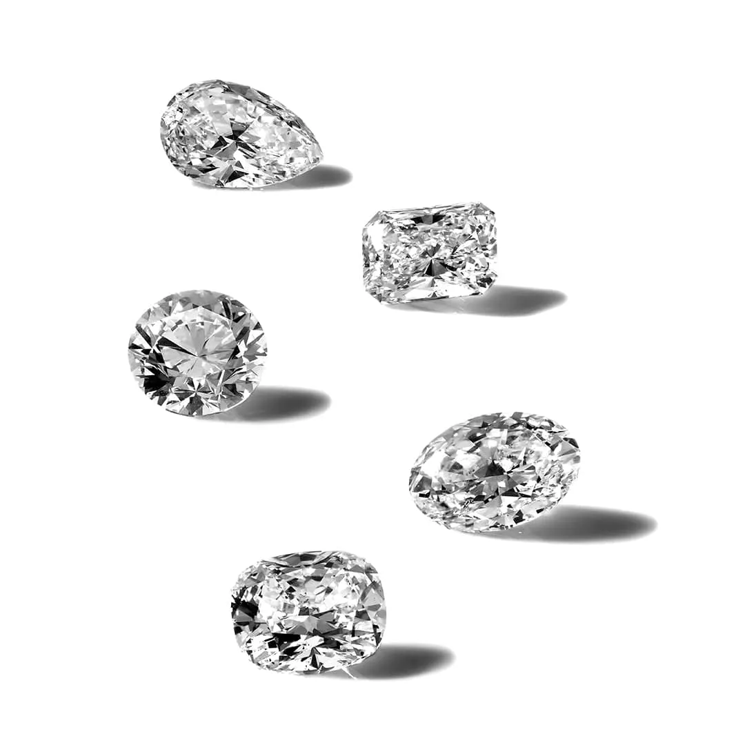 Certified diamonds in round, cushion, oval and pear cuts on a white surface