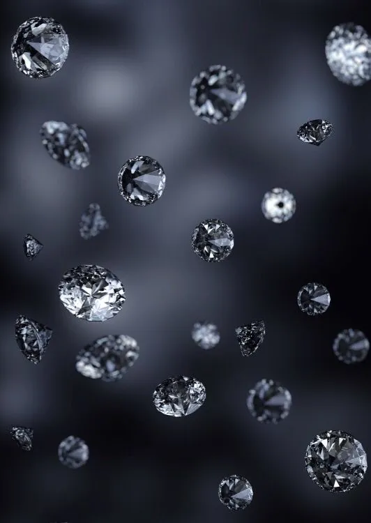 Loose round brilliant diamonds scattered on a dark surface