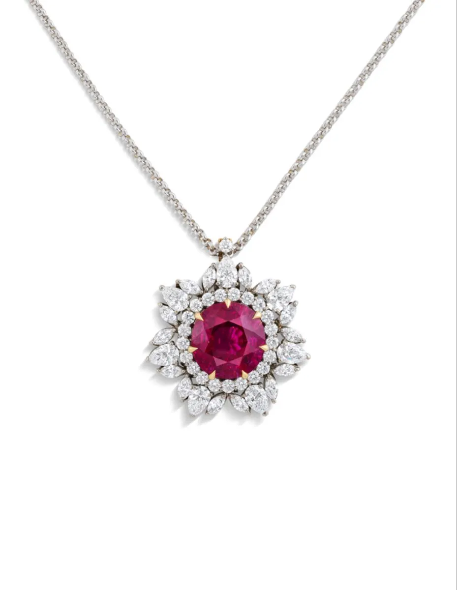 Cushion ruby pendant framed by pear and round diamonds on a white gold chain